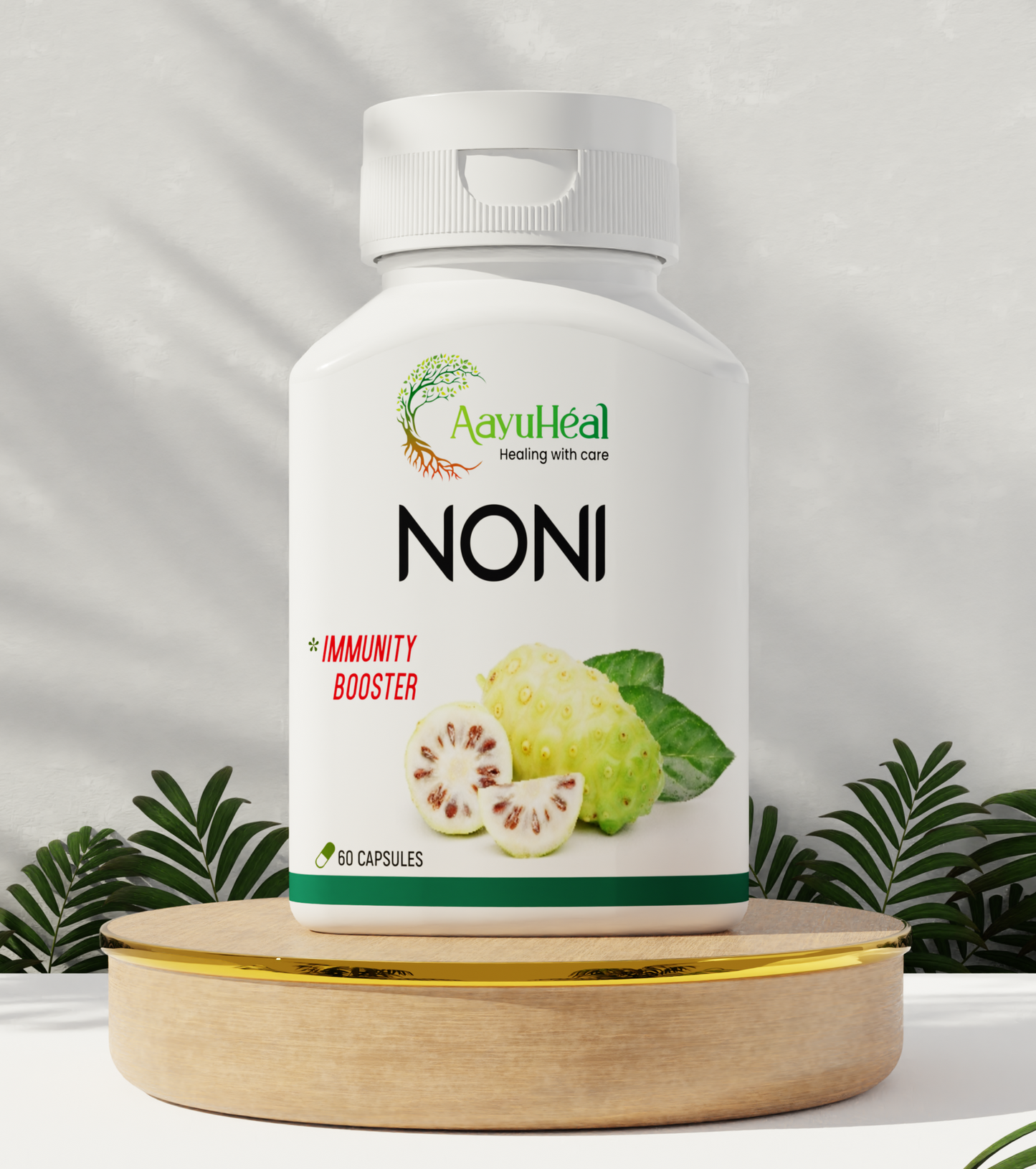 A bottle of Noni Extract capsules placed on a wooden table with a green background and various plants around. The label on the bottle includes the brand 'Aayu' and the product name 'Noni' with additional text that may be product-related.