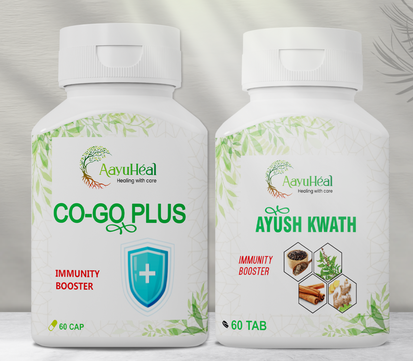 Two white supplement bottles from AayuHeal shown side by side on a light gray background. The left bottle is labeled 'CO-GO PLUS' and the right bottle is labeled 'AYUSH KWATH', both with green leaf graphics and white caps.